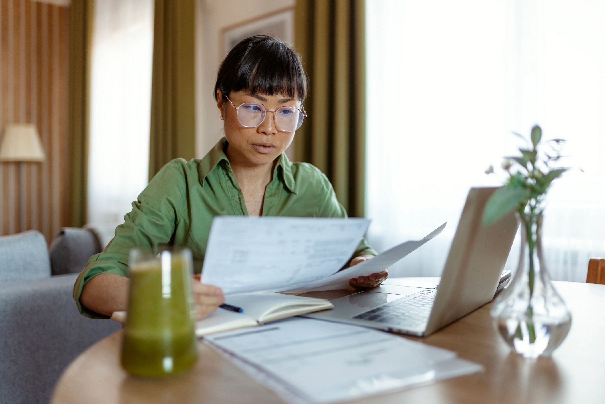 Person reviewing bookkeeping documents with a laptop